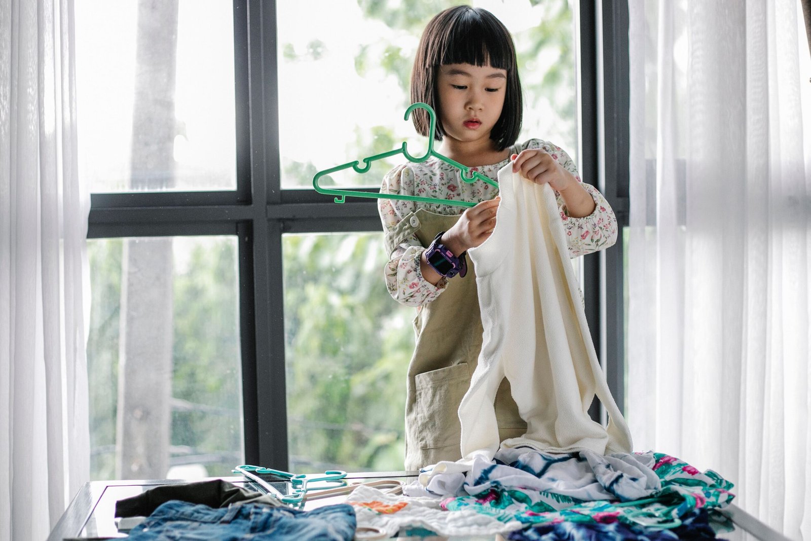 Child organizing clean clothes for gentle wash and dry care