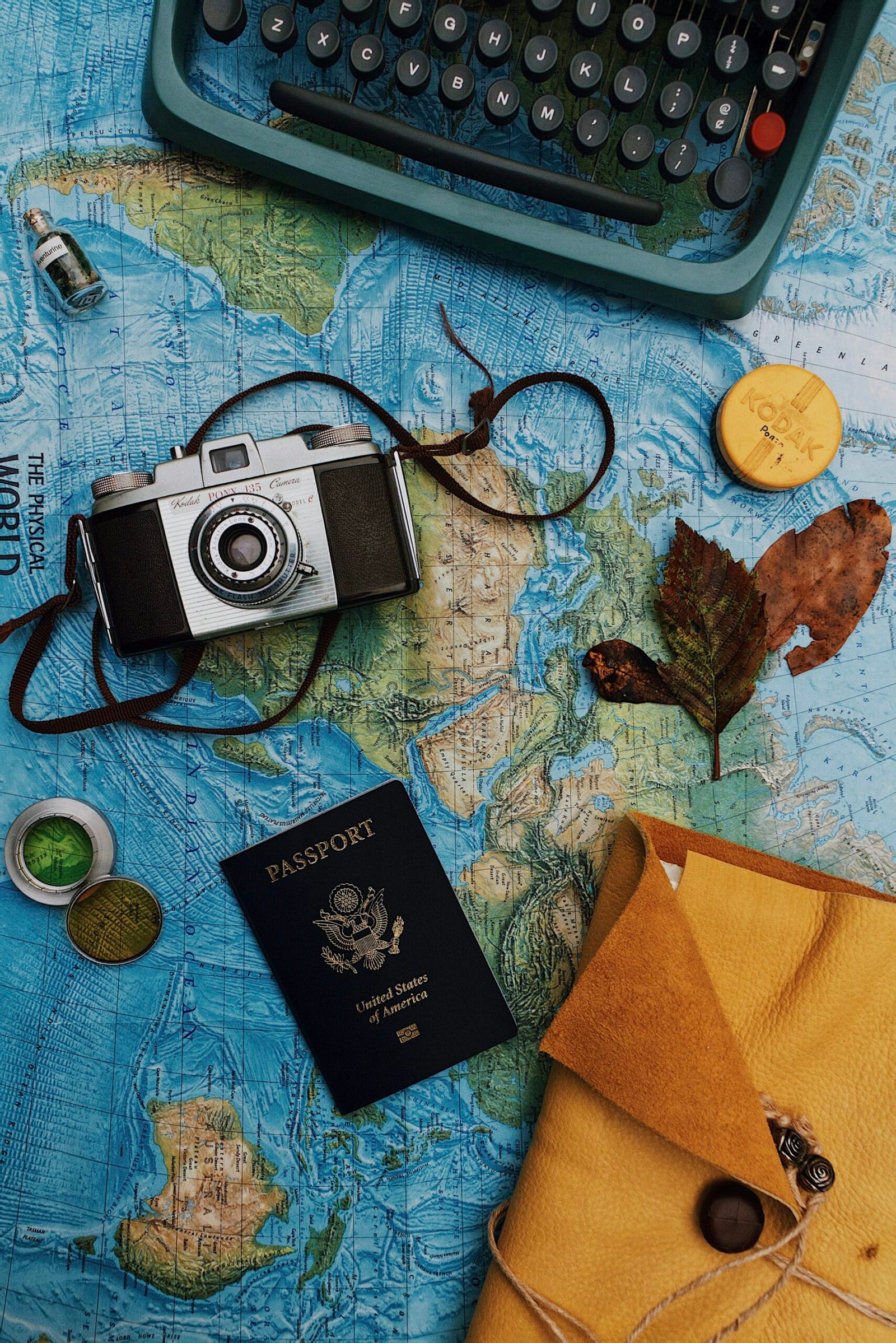 Passport and travel essentials beside a laptop