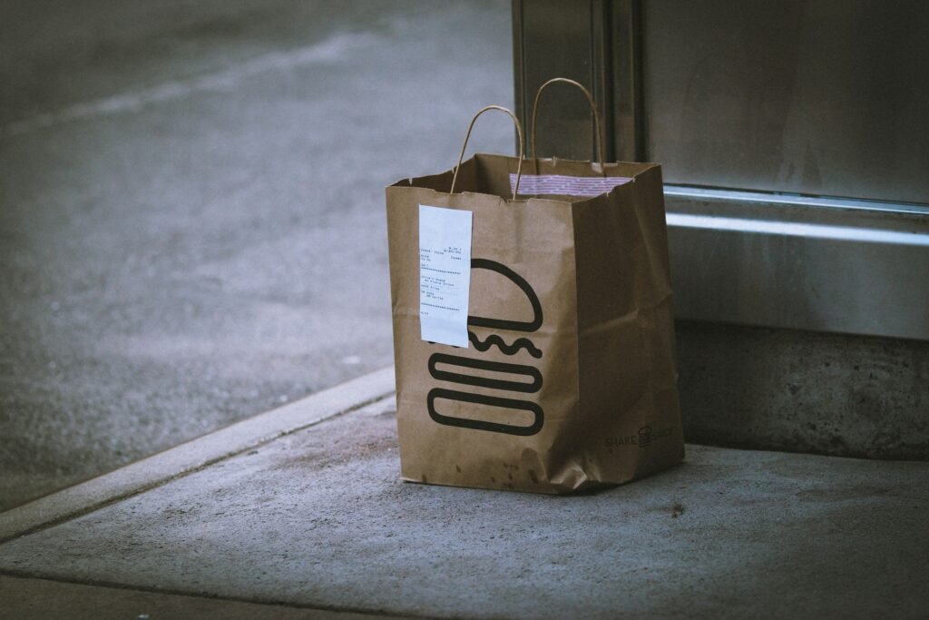 Paper grocery delivery bag placed outside a doorway