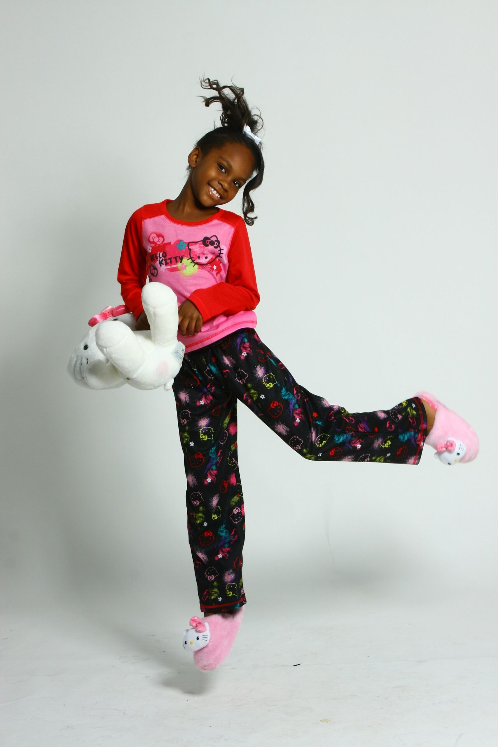 Child holding a plush toy while wearing comfortable clothes